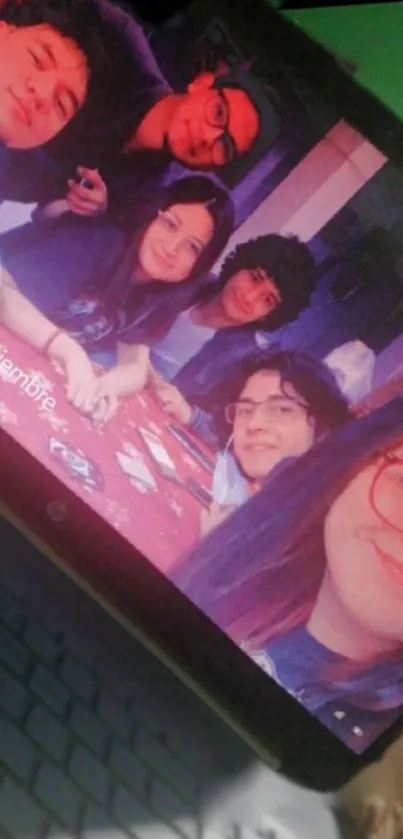 Group selfie displayed on a laptop screen with colorful surroundings.