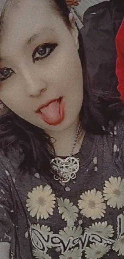 Stylish person with daisy shirt and grunge look, tongue out.