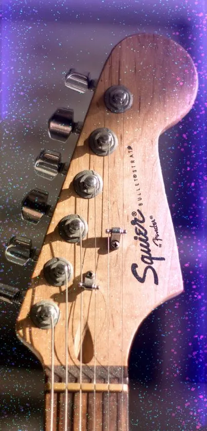 Close-up of a guitar headstock with blurred background.