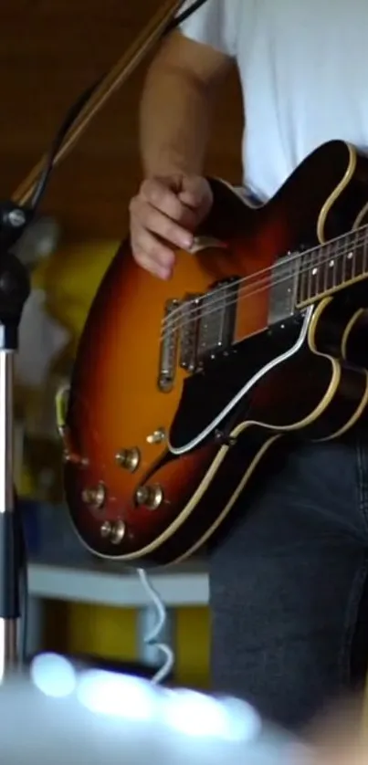 Close-up of a guitarist playing electric guitar on a casual stage setting.