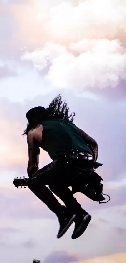 Guitarist jumps with guitar against a colorful sunset sky.