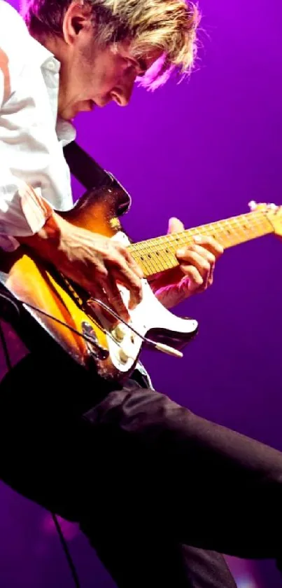 Guitarist performing live with electric guitar and vibrant stage lighting.