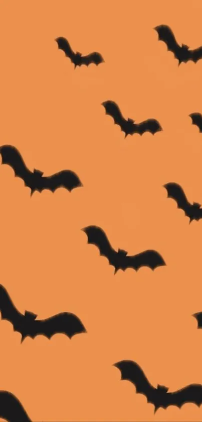 Orange background with black bat silhouettes for Halloween wallpaper.