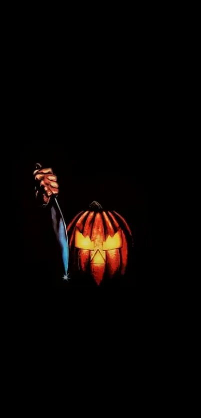 Halloween mobile wallpaper with glowing pumpkin and knife on a black background.