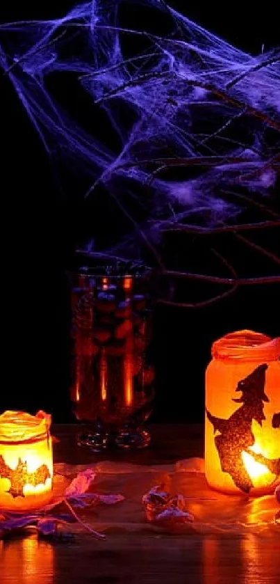 Glowing Halloween lanterns and carved pumpkin with candles.