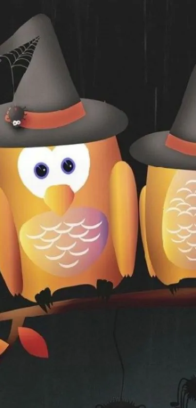 Halloween wallpaper with two owls wearing witch hats on a branch.