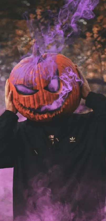 Person wearing pumpkin head with purple smoke in a spooky forest.