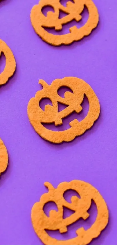 Orange jack-o'-lanterns on a purple background create a festive Halloween wallpaper.