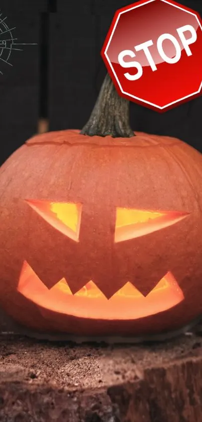 Carved pumpkin with glowing face and stop sign for Halloween.