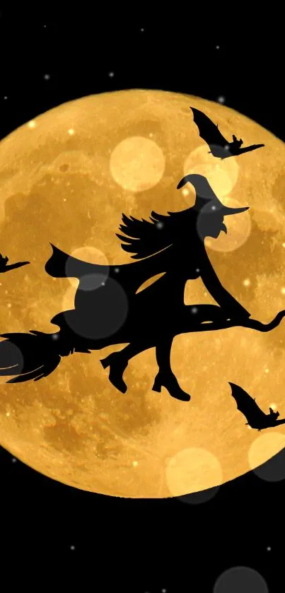 Silhouetted witch and bats flying before a golden full moon.