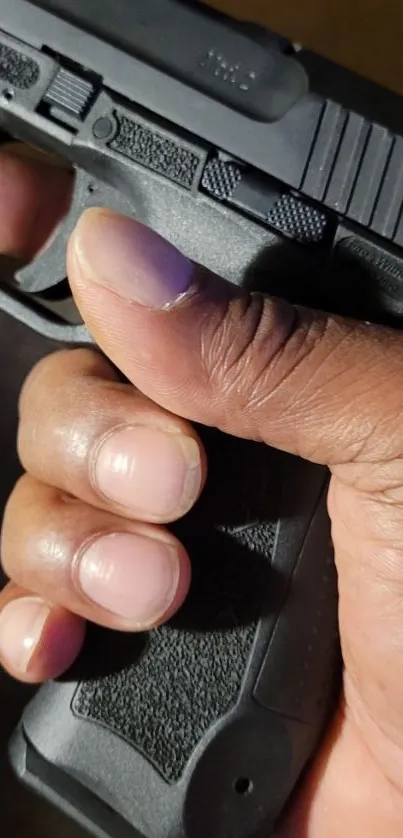 Close-up of a hand holding a black handgun.