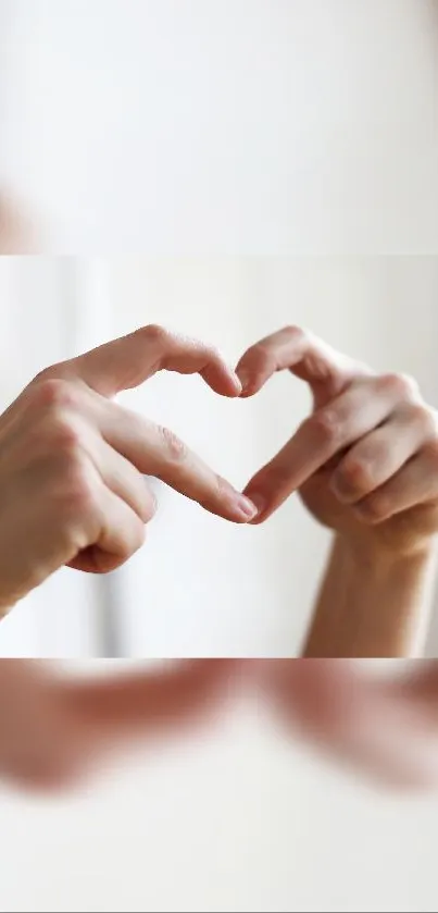 Hands forming a heart shape in soft focus.