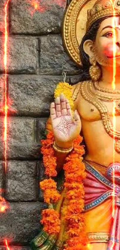 Colorful Hanuman statue with marigold garland against stone temple.