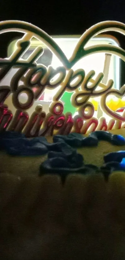 Happy Anniversary text with colorful cake decorations in the background.