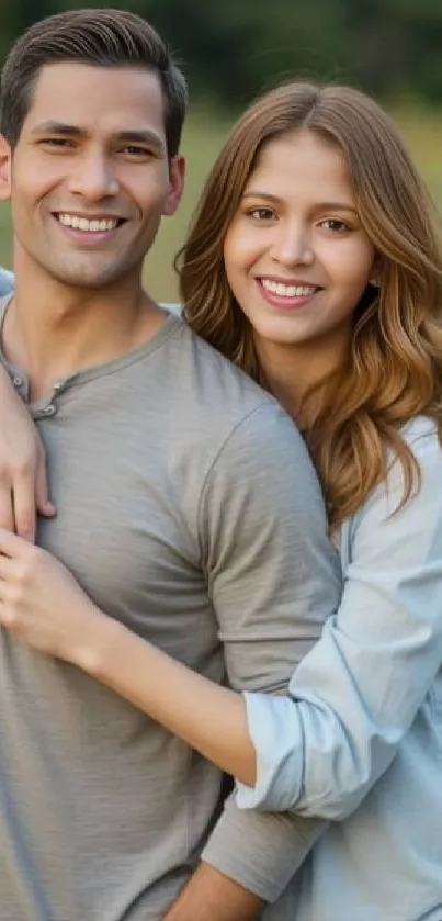 Smiling couple in a natural outdoor setting, embracing each other.