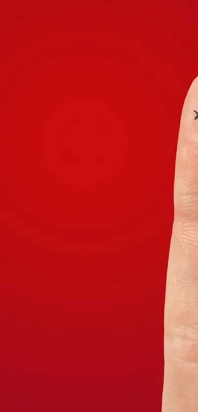 Finger with a smiley face on a vibrant red background.