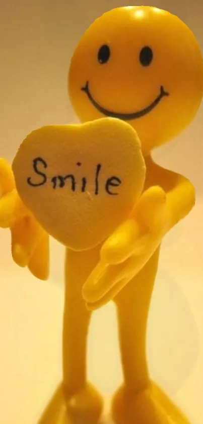 A cheerful yellow smiley holding a heart with 'Smile' written on it.