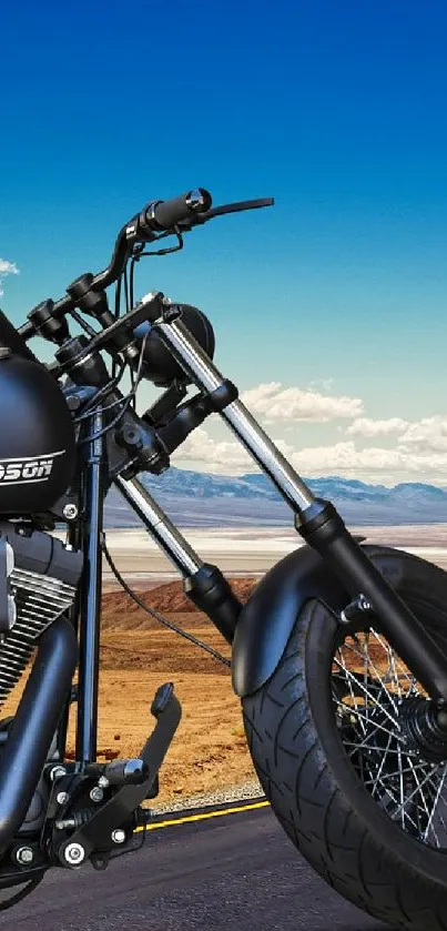 Harley Davidson motorcycle on desert road under blue sky.