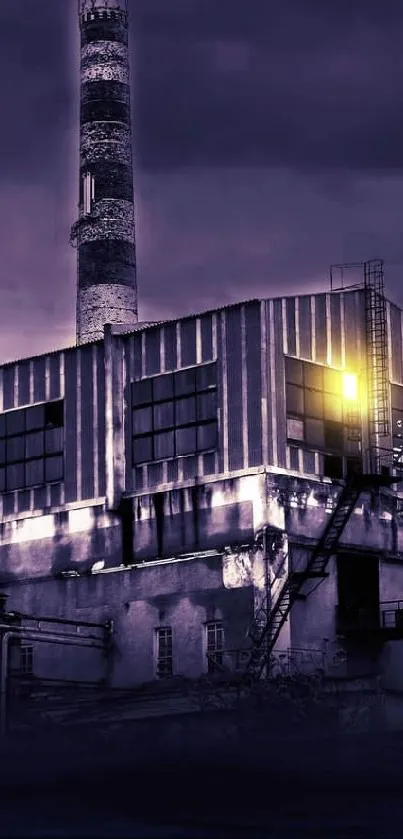 An industrial building under a purple sky at night.