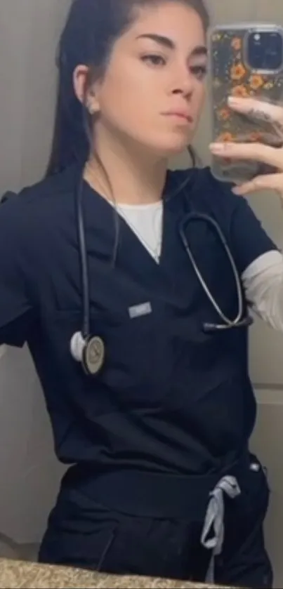 Healthcare worker taking a mirror selfie in navy blue scrubs.