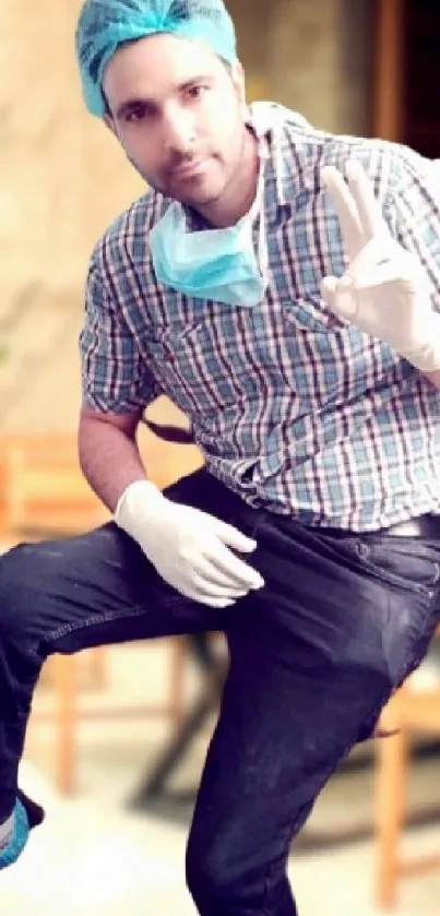 Healthcare professional with protective gear and peace sign.