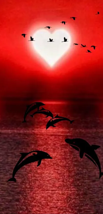 Dolphins and heart silhouette at sunset over the ocean.