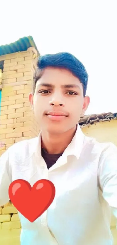 Young man smiling with a heart overlay in a rural setting.