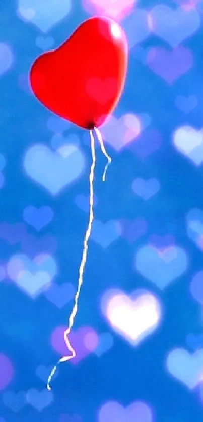 Red heart balloon floating in a clear blue sky.