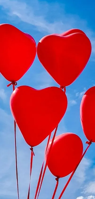 Heart-shaped red balloons float against a bright blue sky backdrop.