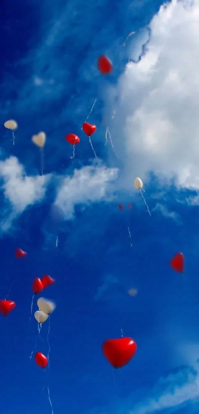 Red heart balloons floating in blue sky.