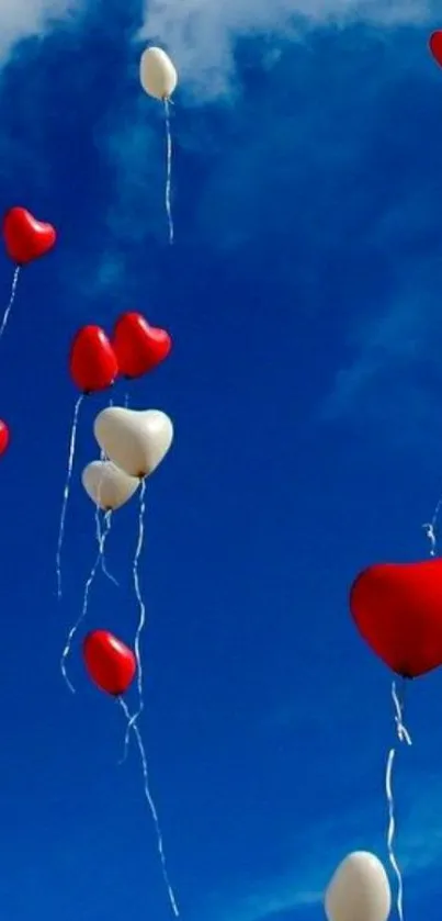 Heart-shaped balloons floating in a blue, cloudy sky.