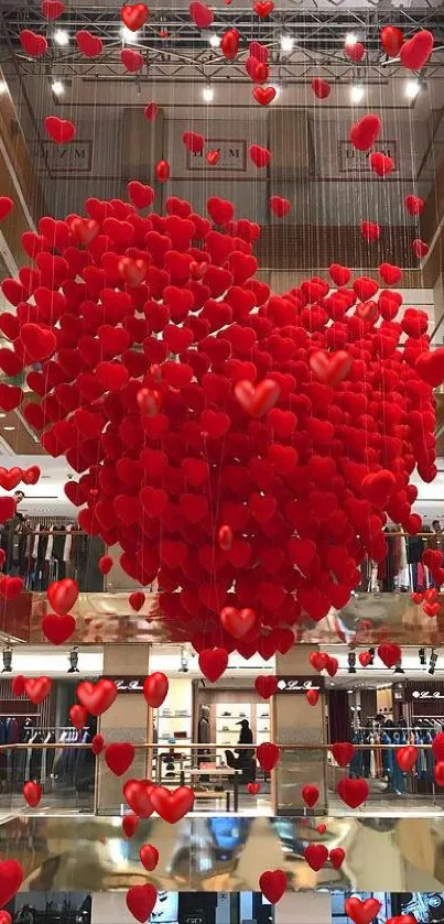 Red heart-shaped balloons decorate a shopping mall interior, creating a romantic ambience.