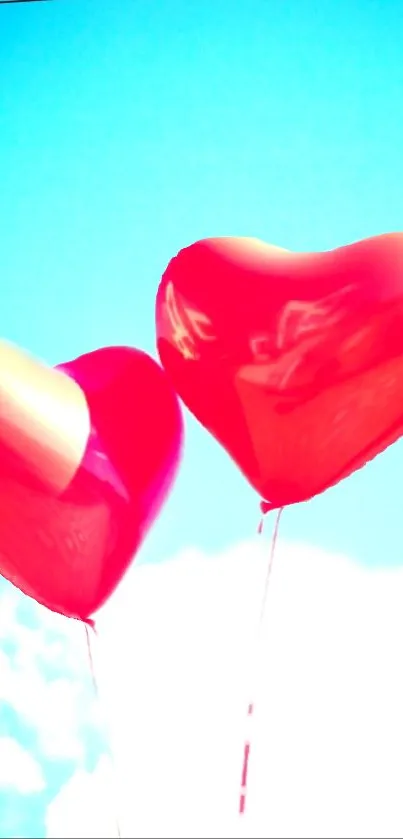 Red heart balloons float in blue sky.