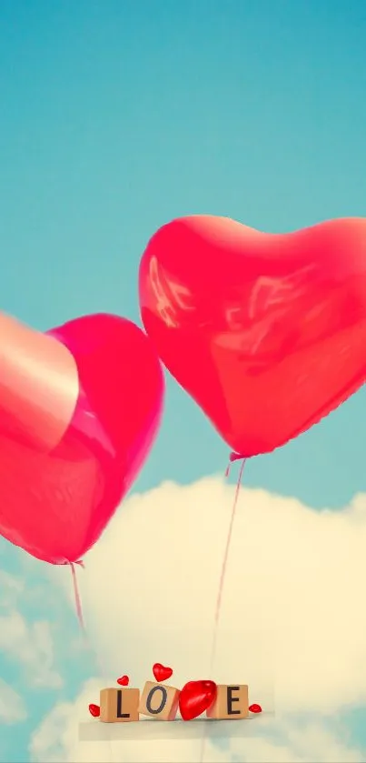 Two red heart-shaped balloons float in a bright blue sky.