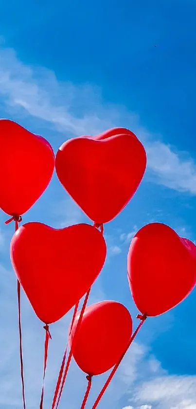 Red heart-shaped balloons floating in a clear blue sky.