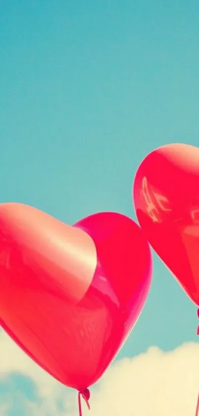 Heart balloons floating in a clear blue sky with clouds.