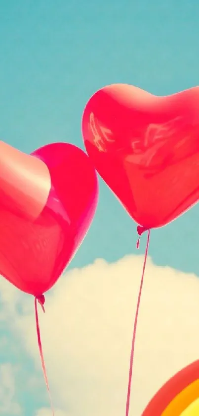 Heart balloons against a bright sky with a rainbow below.