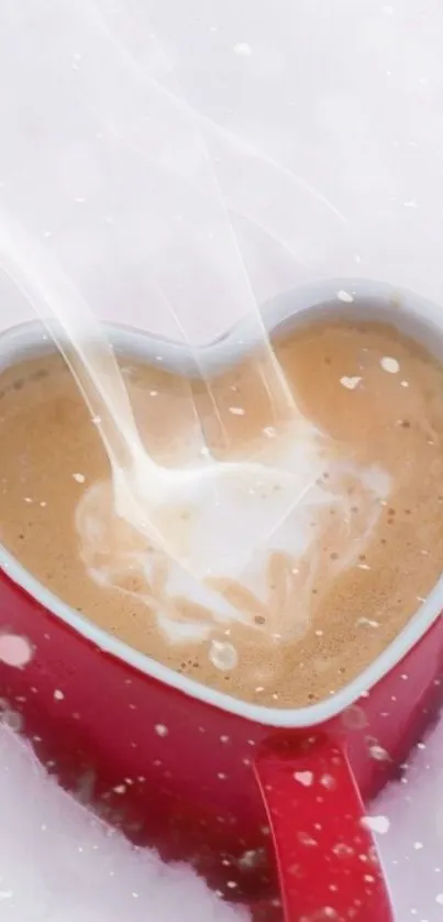 Heart-shaped red mug of coffee in snow with steam rising.