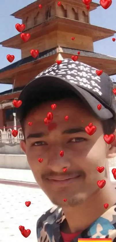 Person smiling in front of temple with red heart overlays.