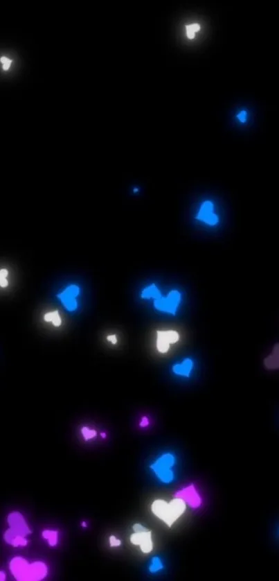 Glowing pink, blue, and white hearts on black background wallpaper.