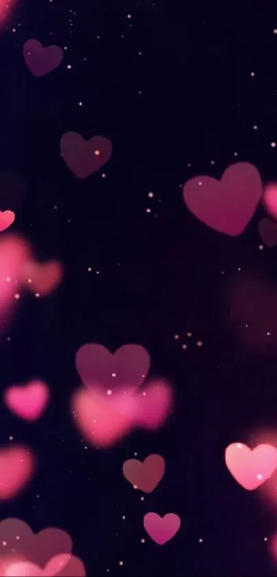 Pink hearts glowing on a dark background wallpaper.