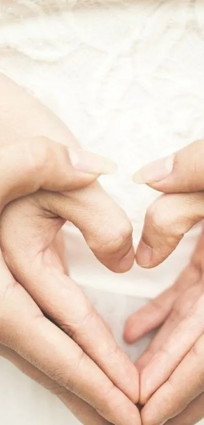 Hands form a heart on a lace wedding dress, symbolizing love and elegance.