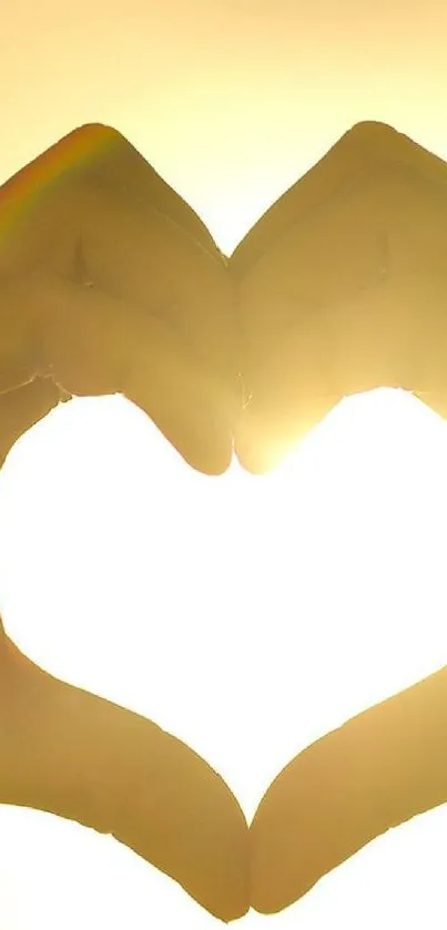 Hands forming heart shape in glowing sunlight, conveying warmth and love.