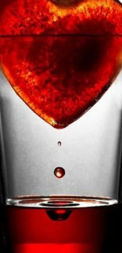 Red heart submerged in a glass, creating a vibrant mobile wallpaper.