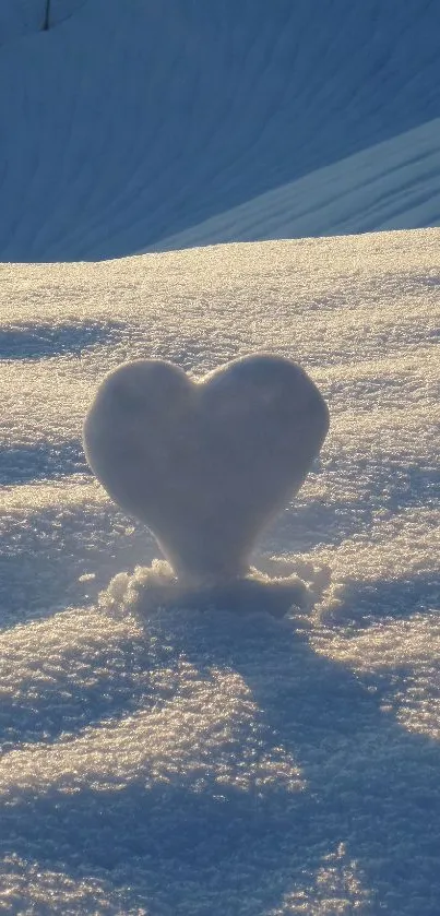 Heart-shaped snow on a sunset-lit snowy landscape.