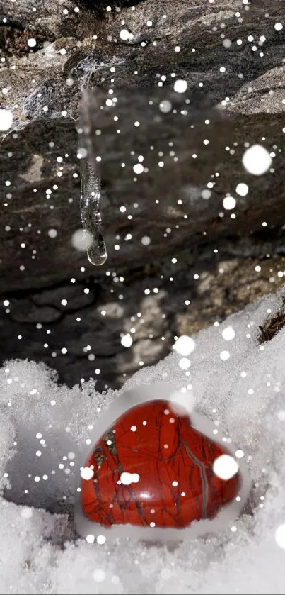 Red heart on snowy landscape with rocks and ice.