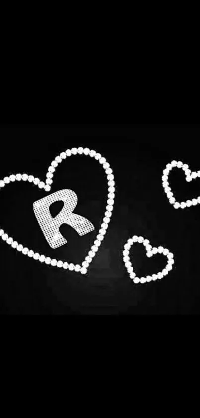 Heart-shaped design with letter R on a black wallpaper background.