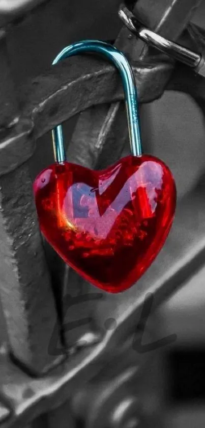 Red heart-shaped lock attached to gray fence.