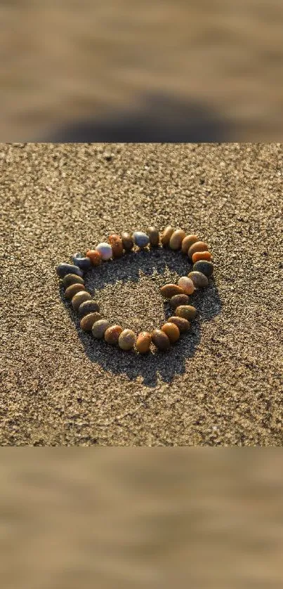 Heart-shaped stone arrangement on sandy beach scene.