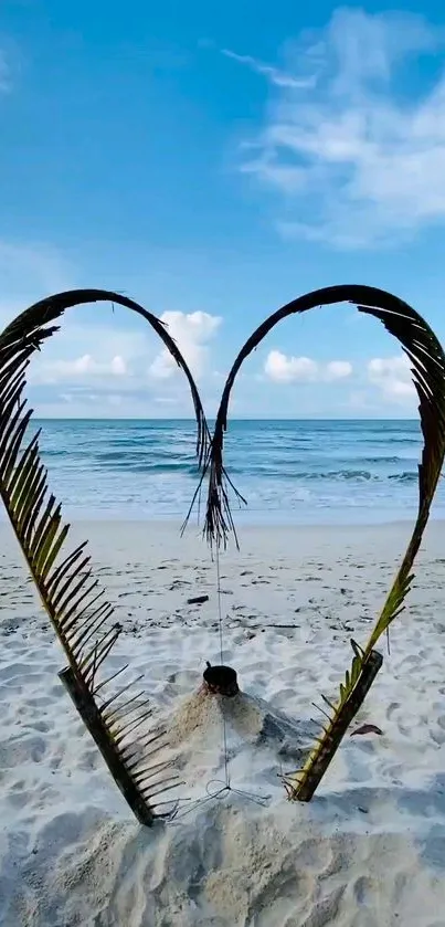 Heart-shaped palm leaves on a sandy tropical beach with blue sky.